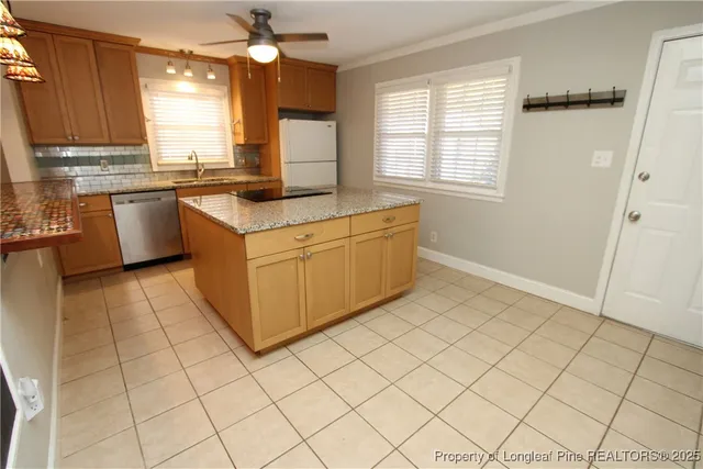 a kitchen with stainless steel appliances granite countertop a sink cabinets and window