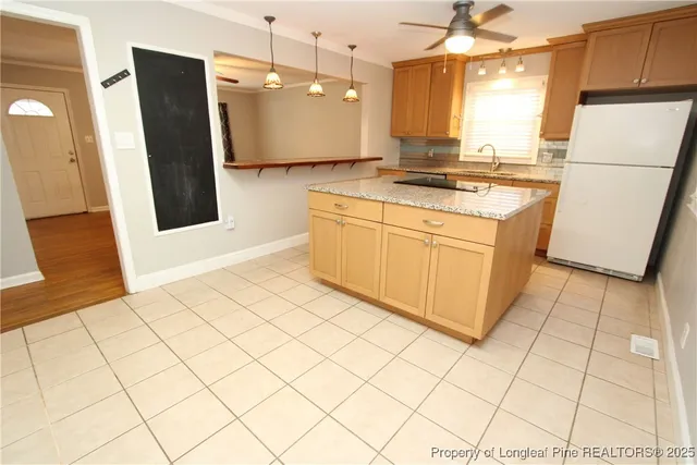 a kitchen with a sink a refrigerator and a stove