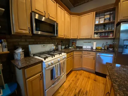 a kitchen with stainless steel appliances granite countertop a stove a sink and a microwave