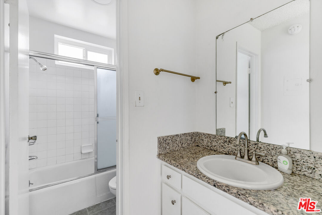 1811 Parnell Avenue, Unit 3 Los Angeles, CA 90025 - Photo 17 of 20 a bathroom with a granite countertop sink shower mirror and a bathtub