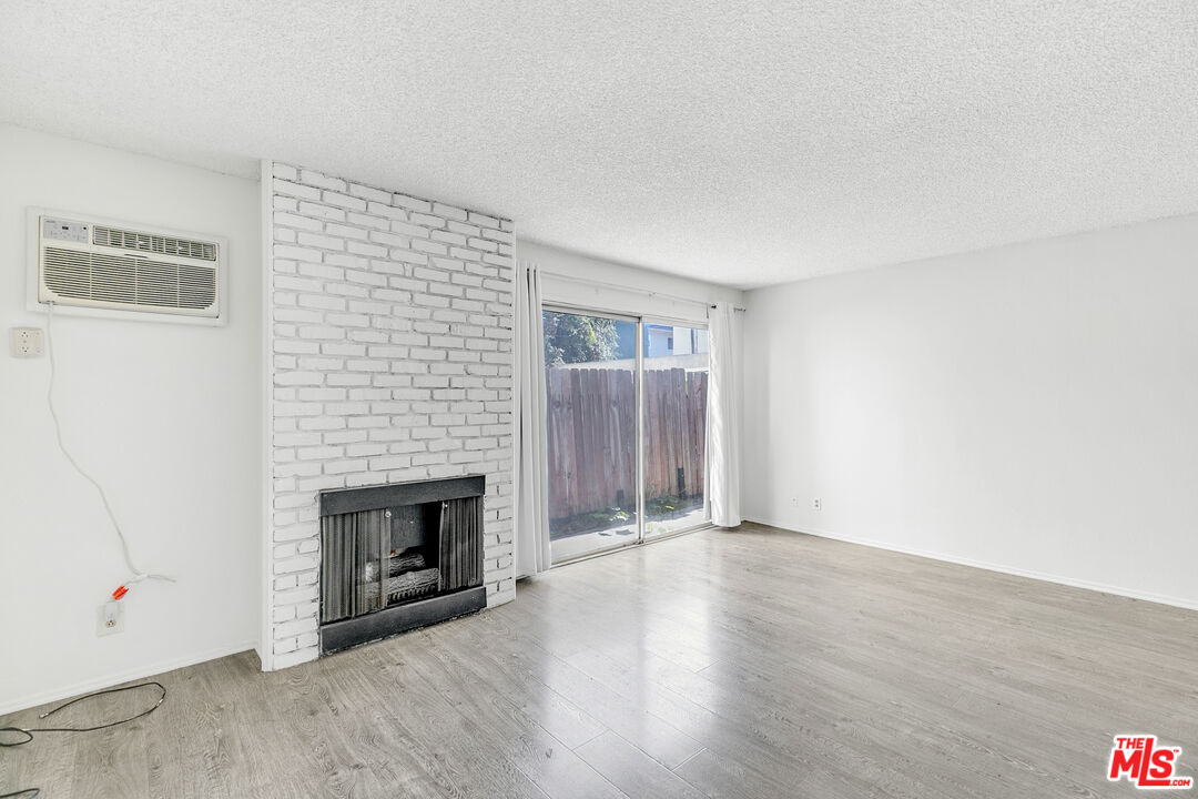 1811 Parnell Avenue, Unit 3 Los Angeles, CA 90025 - Photo 4 of 20 an empty room with wooden floor fireplace and windows