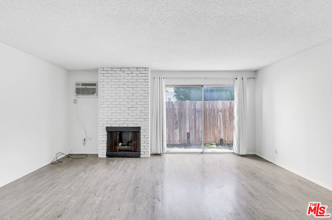 1811 Parnell Avenue, Unit 3 Los Angeles, CA 90025 - Photo 5 of 20 an empty room with wooden floor fireplace and windows