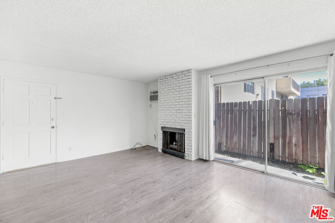 1811 Parnell Avenue, Unit 3 Los Angeles, CA 90025 - Photo 6 of 20 an empty room with floor to ceiling window and fireplace