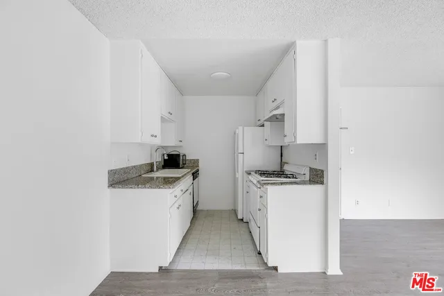 a kitchen with a stove top oven and cabinets