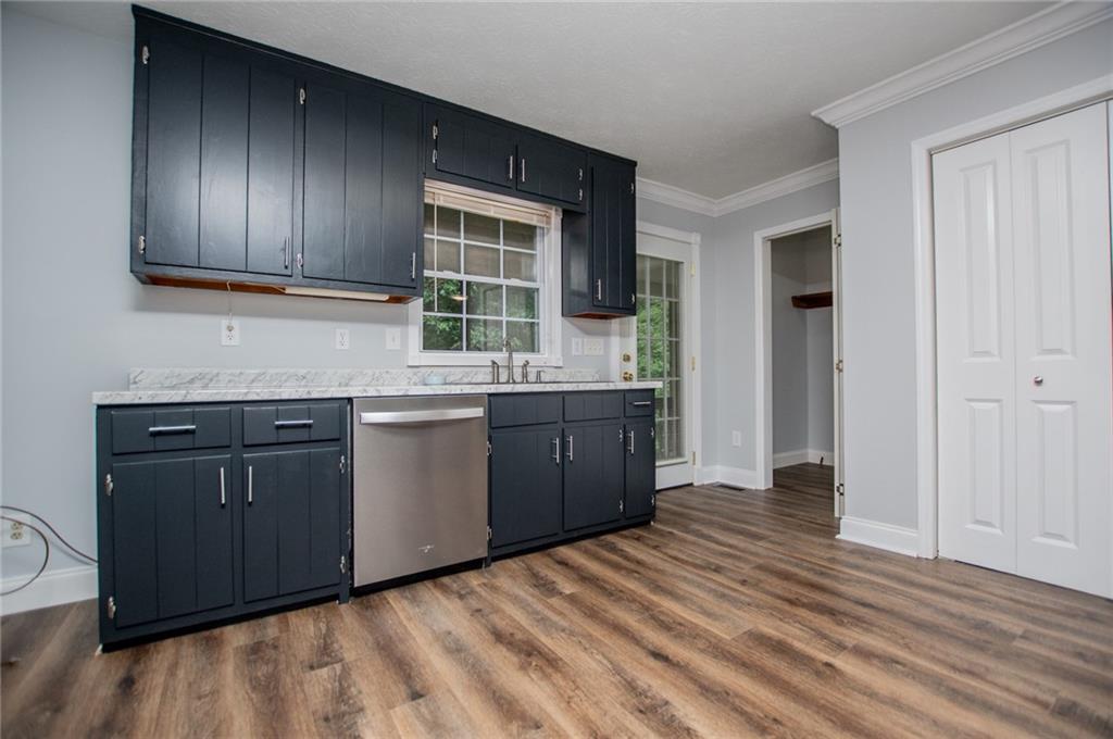 8291 Highway 5 Winston, GA 30187 - Photo 27 of 65 a kitchen with stainless steel appliances granite countertop a sink and cabinets with wooden floor