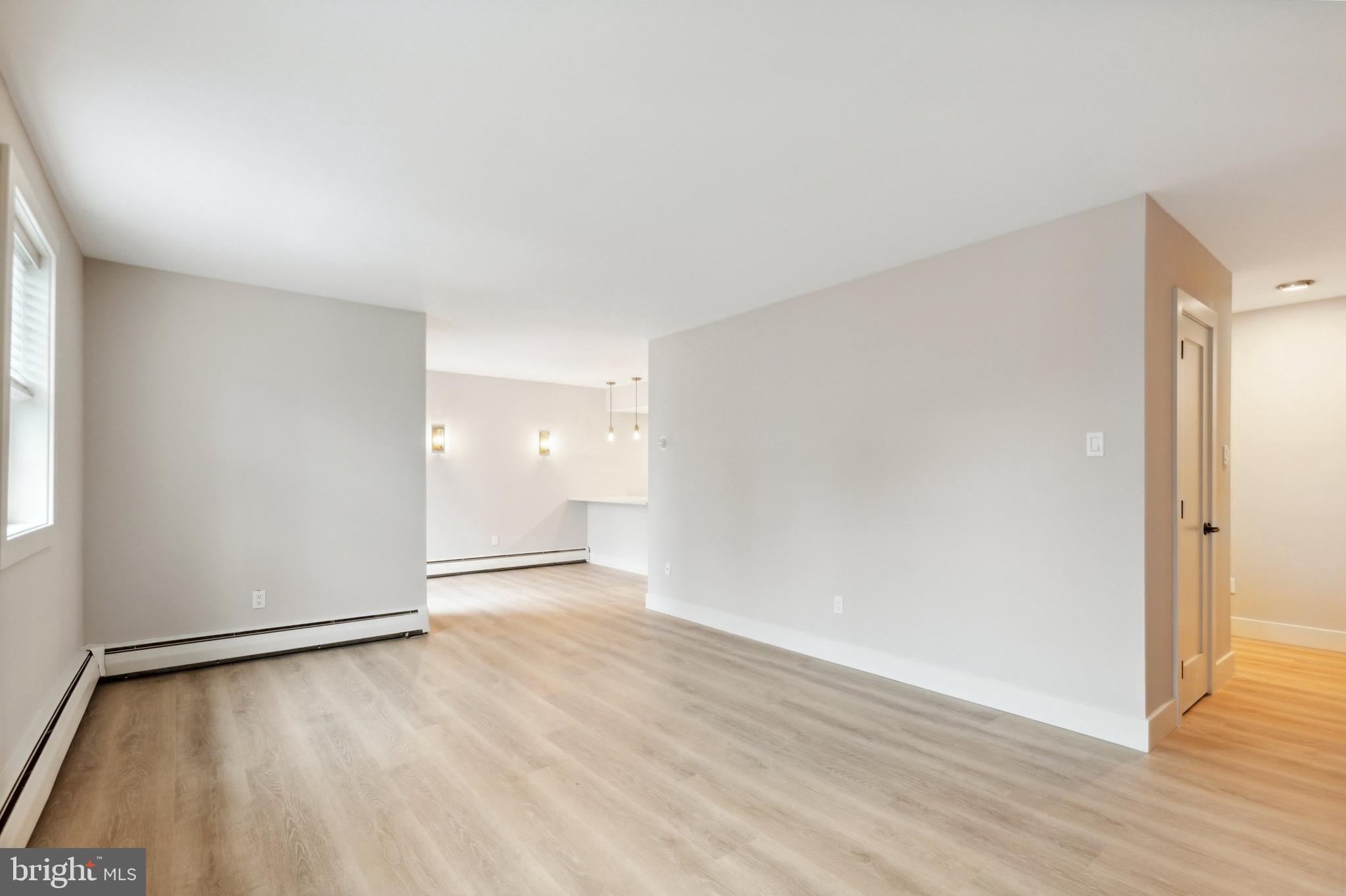 176 West King Street, Unit 311 Malvern, PA 19355 - Photo 4 of 9 an empty room with wooden floor and windows