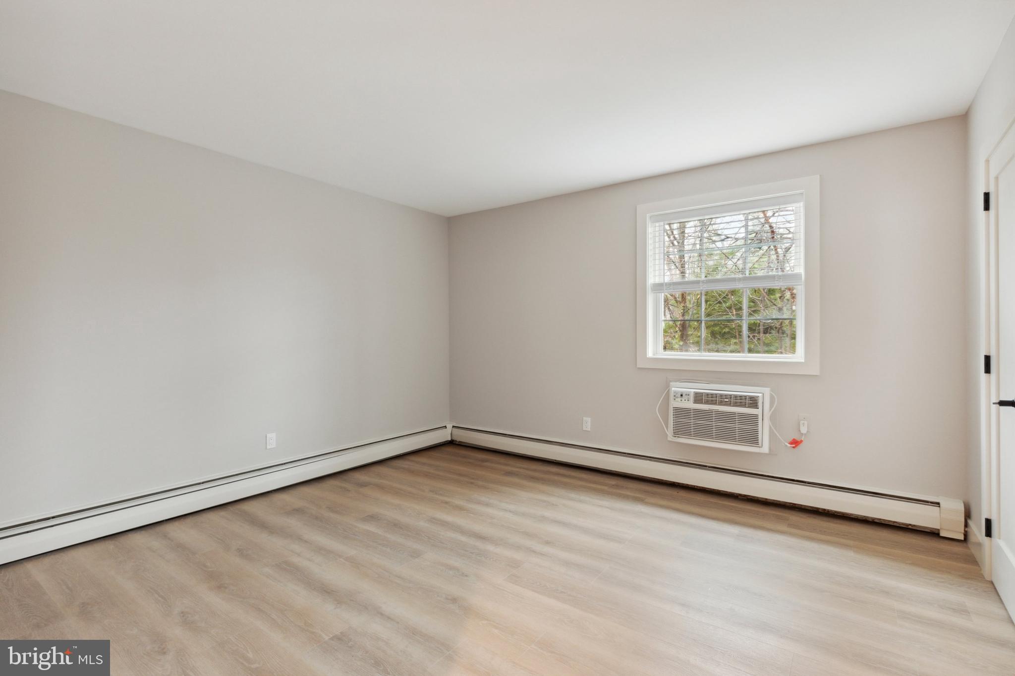 176 West King Street, Unit 311 Malvern, PA 19355 - Photo 7 of 9 an empty room with wooden floor and windows