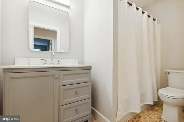 a bathroom with a sink a toilet and a mirror