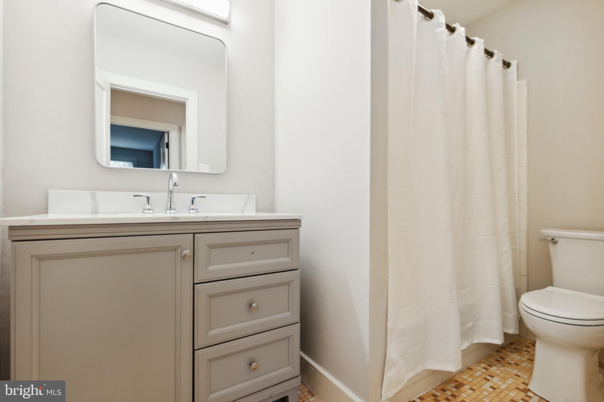 176 West King Street, Unit 311 Malvern, PA 19355 - Photo 9 of 9 a bathroom with a sink a toilet and a mirror