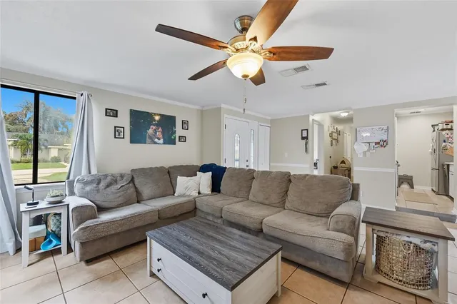 a living room with furniture a ceiling fan and a window