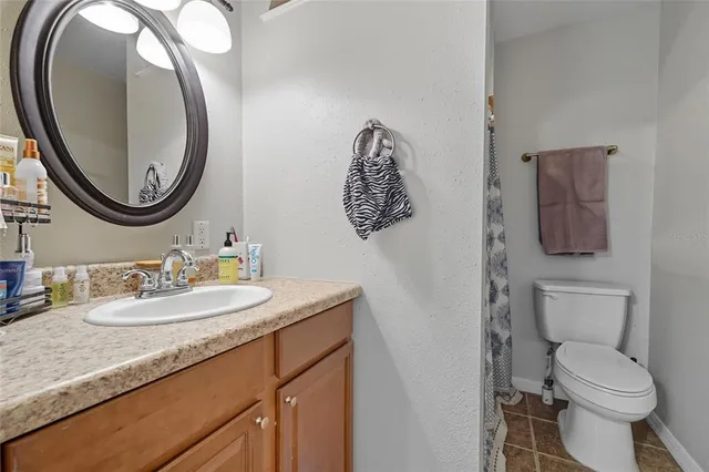 a bathroom with a toilet a sink and a mirror