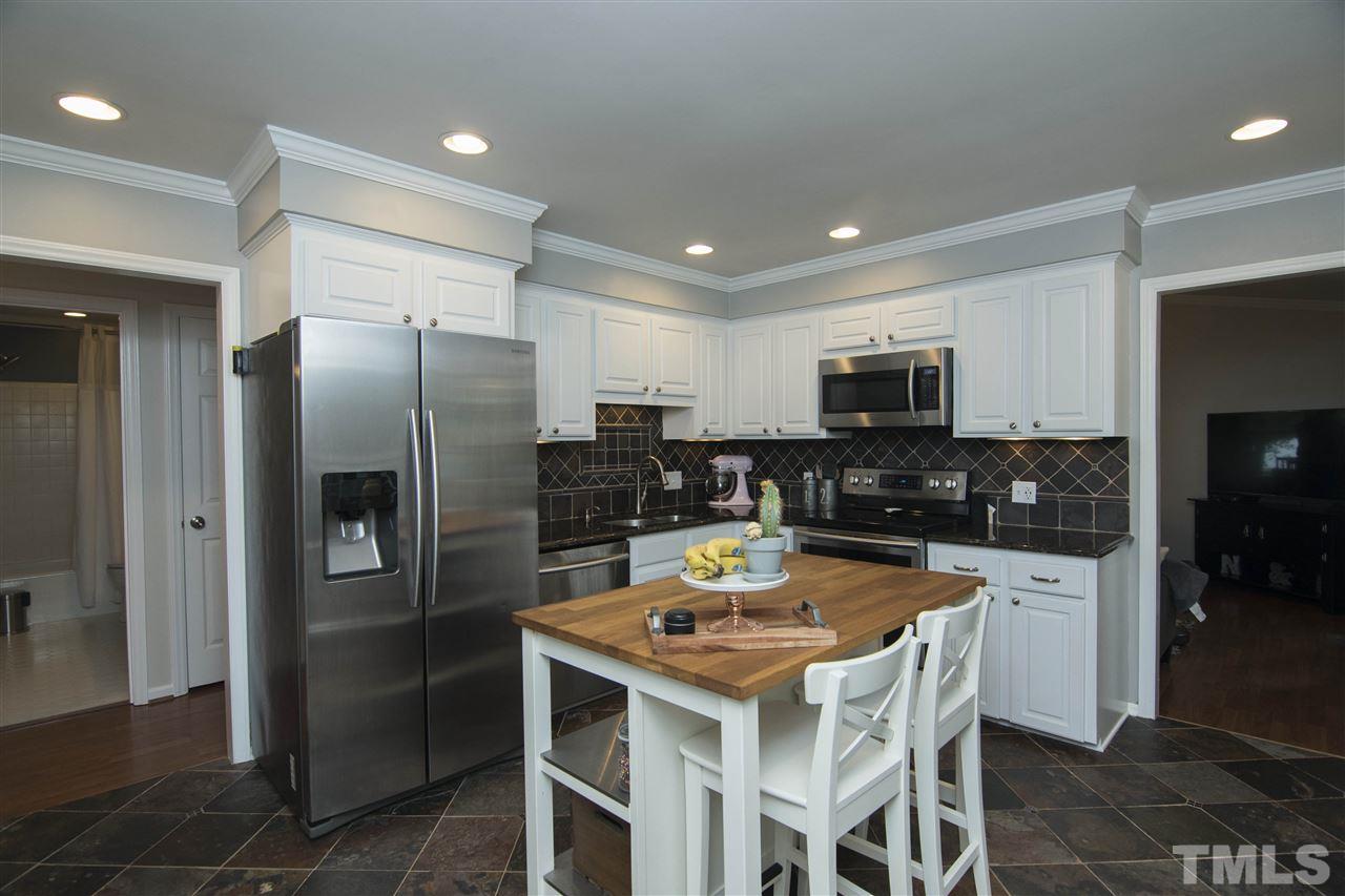 7408 Post Oak Road Raleigh, NC 27615 - Photo 13 of 27 a kitchen with a refrigerator a stove a sink and chairs
