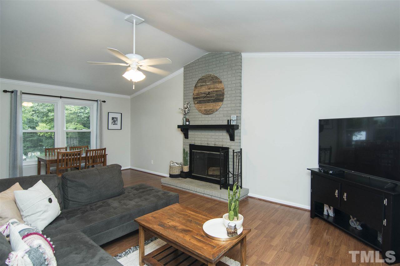 7408 Post Oak Road Raleigh, NC 27615 - Photo 19 of 27 a living room with furniture a flat screen tv and a fireplace