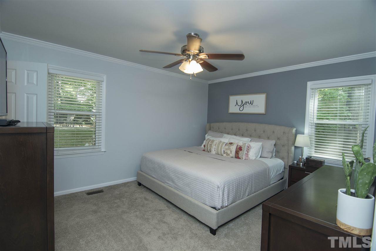 7408 Post Oak Road Raleigh, NC 27615 - Photo 25 of 27 a bedroom with a bed and a chandelier