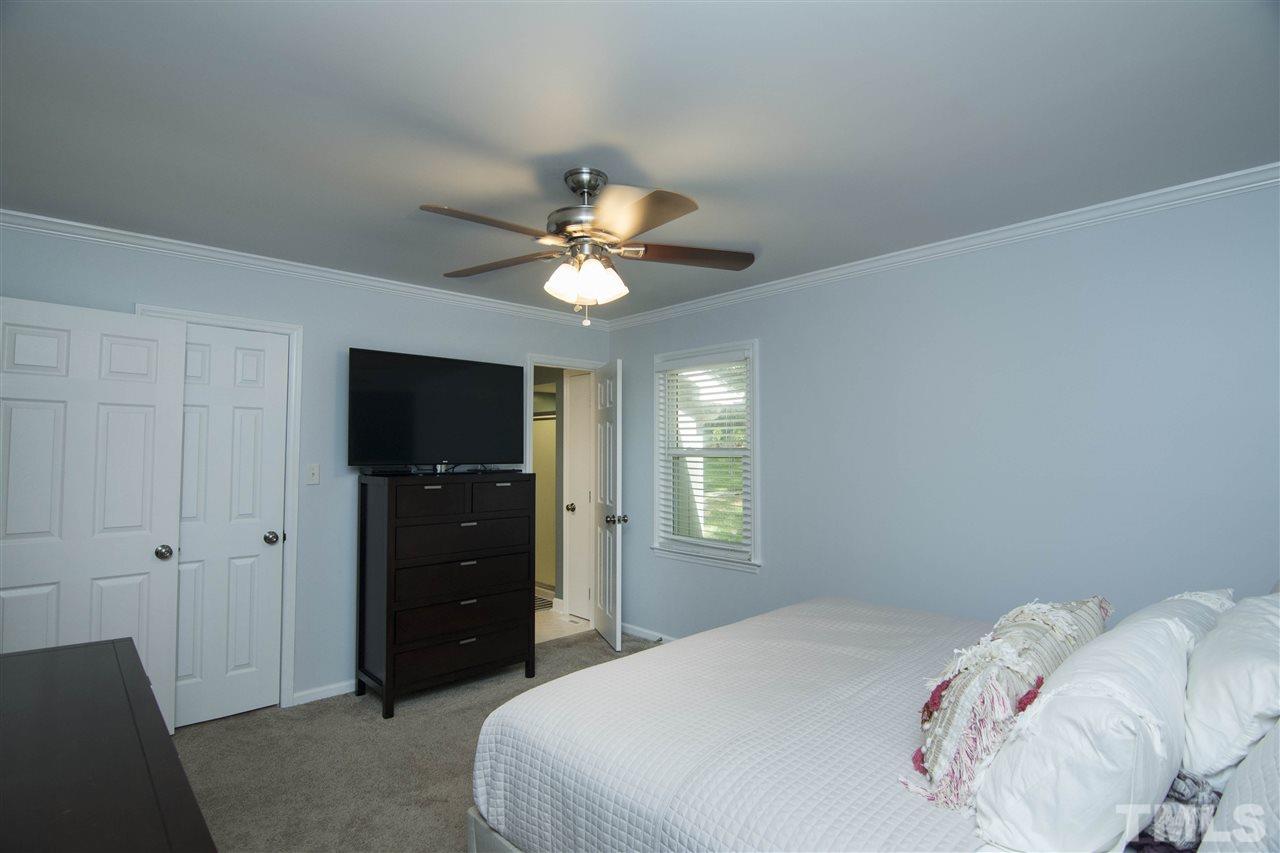 7408 Post Oak Road Raleigh, NC 27615 - Photo 26 of 27 a bedroom with a bed and a chandelier