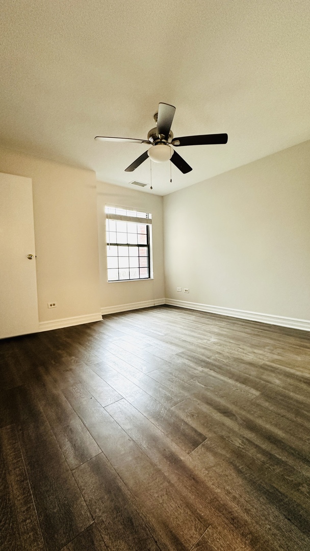 2014 North Rand Road, Unit 108 Palatine, IL 60074 - Photo 12 of 16 an empty room with wooden floor and windows