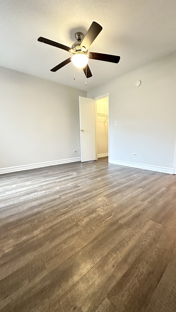 2014 North Rand Road, Unit 108 Palatine, IL 60074 - Photo 13 of 16 an empty room with wooden floor ceiling fan and windows