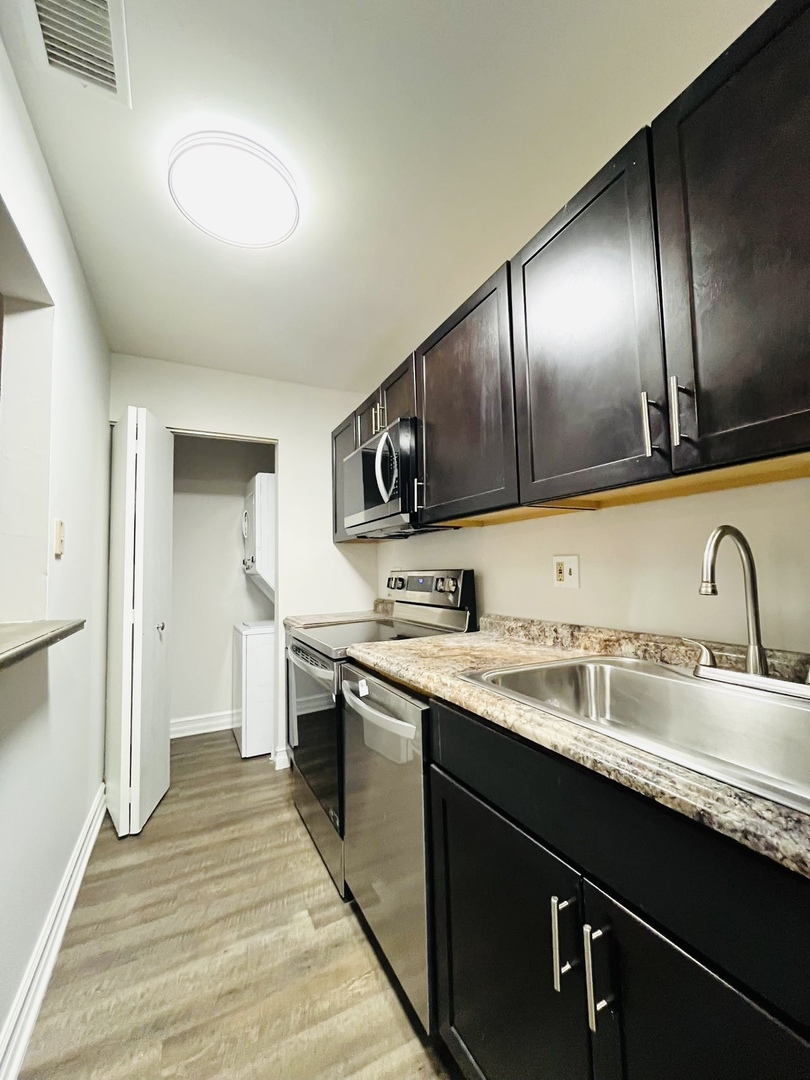 2014 North Rand Road, Unit 108 Palatine, IL 60074 - Photo 7 of 16 a kitchen with granite countertop stainless steel appliances a sink stove top oven and cabinets