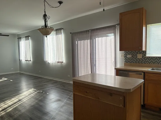 a kitchen with kitchen island large windows and refrigerator