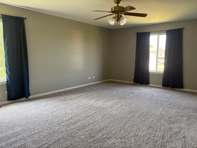 a view of an empty room and a ceiling fan