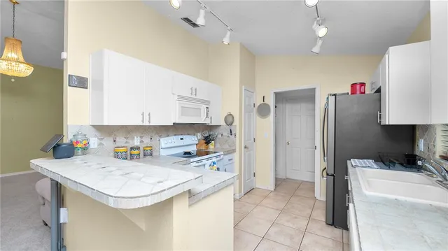 a kitchen with a sink a stove a refrigerator and cabinets