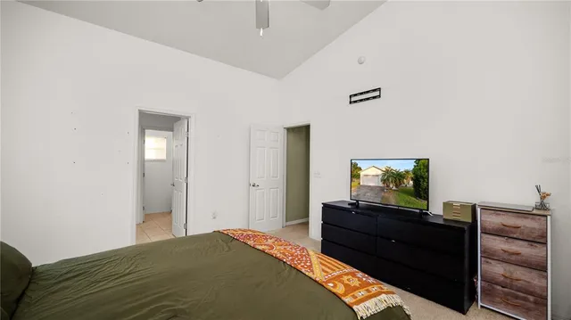 a bedroom with a bed and a flat tv screen on a dresser