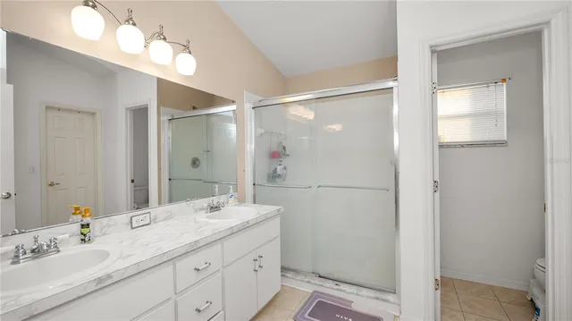 a bathroom with a double vanity sink mirror and shower