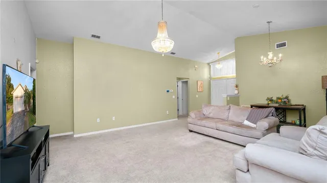 a living room with furniture a lamp and a flat screen tv