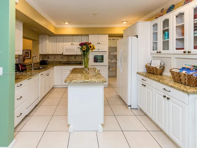 a kitchen with granite countertop a sink and cabinets