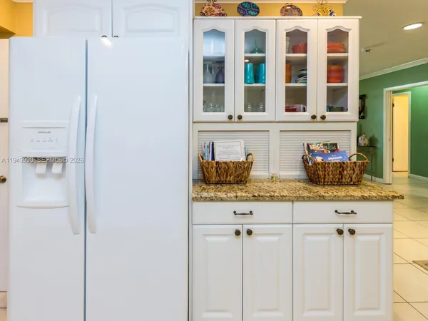 a kitchen with granite countertop white cabinets and stainless steel appliances