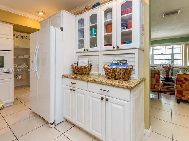 a kitchen with granite countertop white cabinets and white appliances