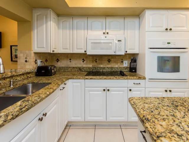 a kitchen with granite countertop a sink and a window