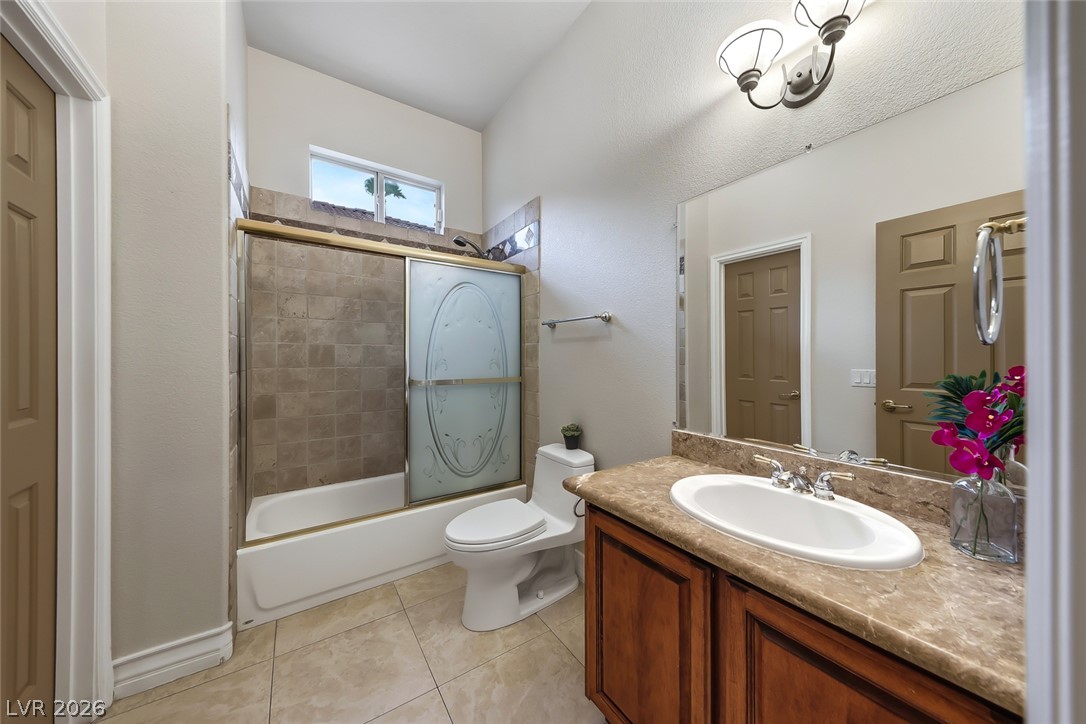 1104 Norellat Road Henderson, NV 89011 - Photo 37 of 52 A polished stone counter and wood vanity complement the tiled tub area.