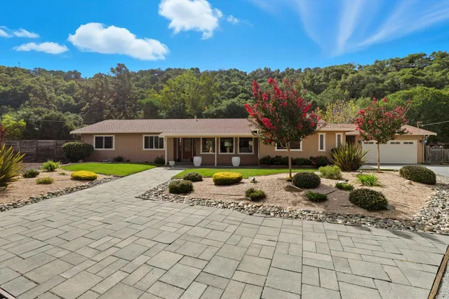a view of a house with backyard and sitting area