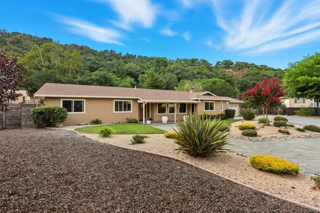 a view of a house with backyard and sitting area