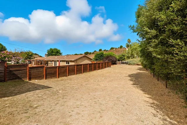 an aerial view of a house with yard swimming pool and mountain view