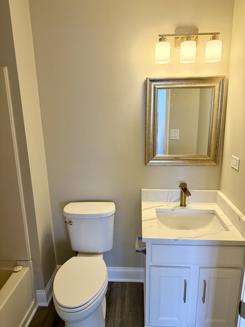 10233 Concord Lane, Unit C Bridgeview, IL 60455 - Photo 12 of 23 a bathroom with a toilet a sink and mirror