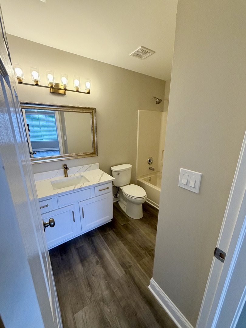 10233 Concord Lane, Unit C Bridgeview, IL 60455 - Photo 15 of 23 a bathroom with a toilet sink and mirror