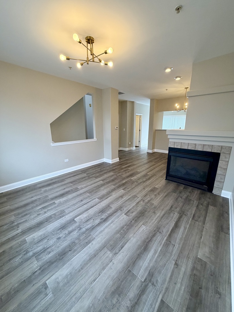 10233 Concord Lane, Unit C Bridgeview, IL 60455 - Photo 4 of 23 a view of an empty room with wooden floor and a chandelier