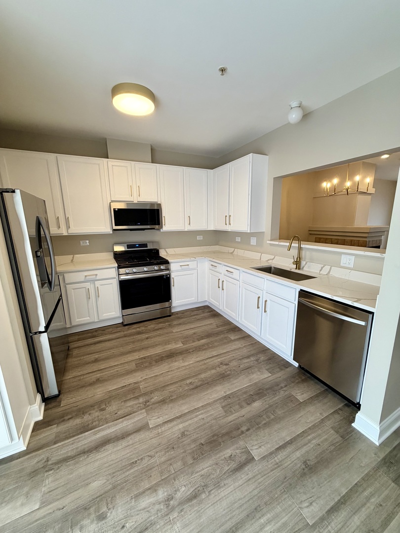 10233 Concord Lane, Unit C Bridgeview, IL 60455 - Photo 7 of 23 a kitchen with stainless steel appliances granite countertop a stove a sink and a refrigerator