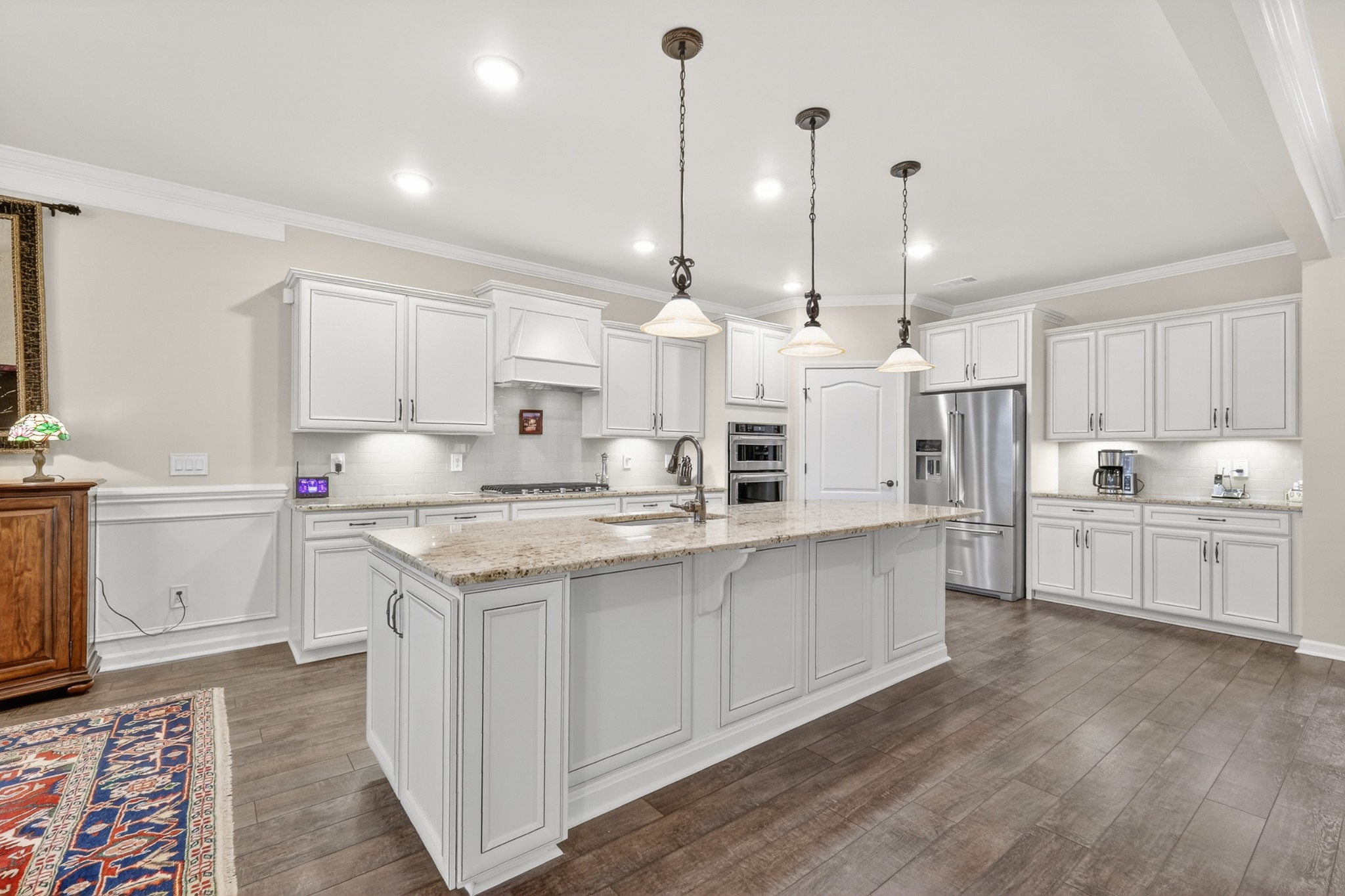 1024 Coffee Ridge Spring Hill, TN 37174 - Photo 13 of 46 a kitchen with stainless steel appliances granite countertop a sink a stove a refrigerator and white cabinets with wooden floor
