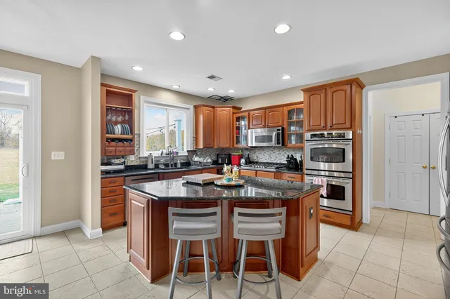 a kitchen with stainless steel appliances granite countertop a sink stove and cabinets