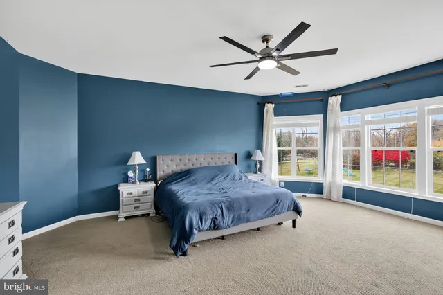 a spacious bedroom with a large bed and a large window