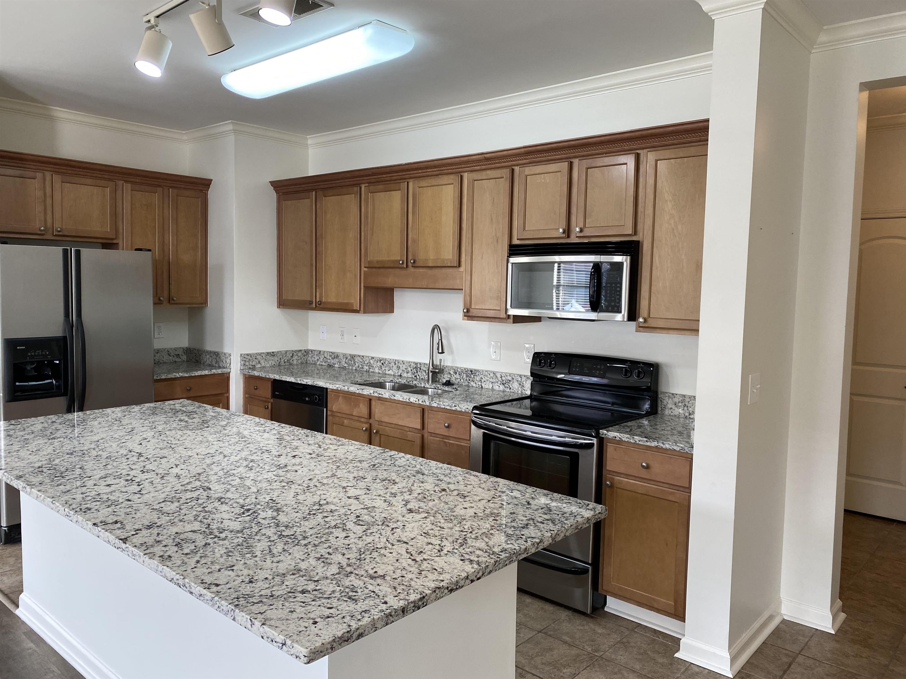 730 Litty Court, Unit 101 Memphis, TN 38103 - Photo 5 of 22 a kitchen with stainless steel appliances granite countertop a stove refrigerator and microwave