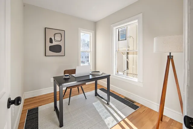 a view of a workspace with furniture and a window