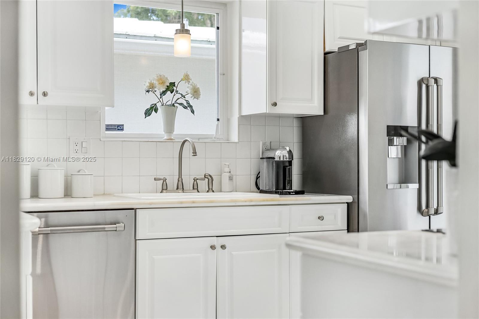 8811 Hawthorne Avenue Surfside, FL 33154 - Photo 24 of 47 a kitchen with stainless steel appliances a refrigerator and cabinets