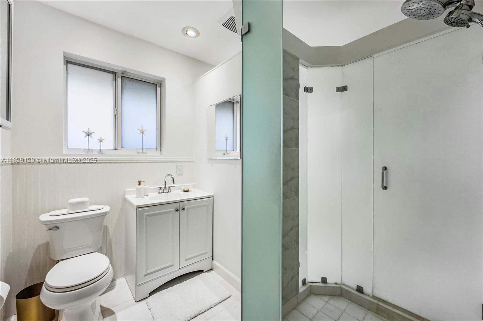 8811 Hawthorne Avenue Surfside, FL 33154 - Photo 29 of 47 a bathroom with a toilet a sink and mirror