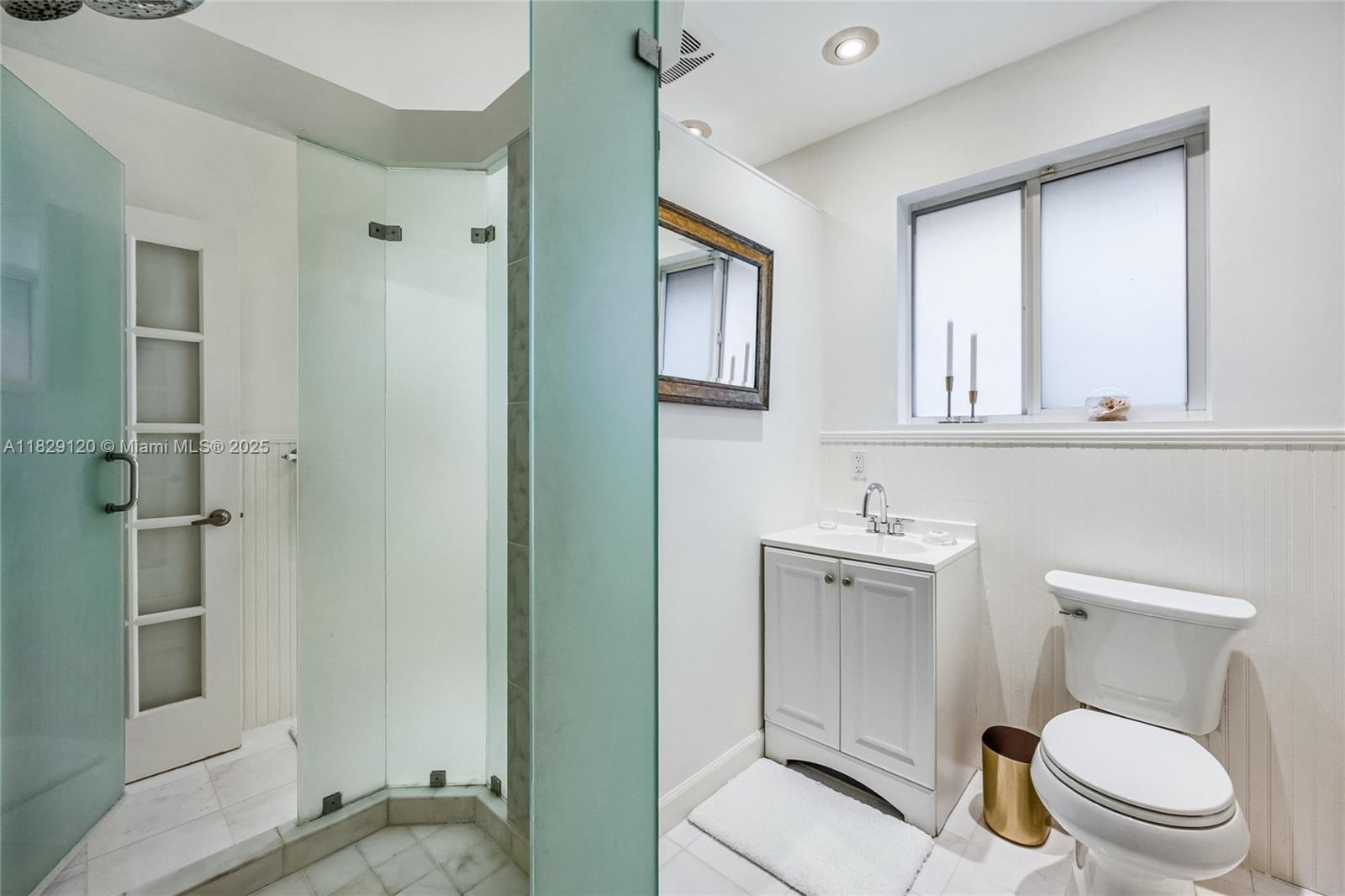 8811 Hawthorne Avenue Surfside, FL 33154 - Photo 32 of 47 a bathroom with a toilet a sink and mirror