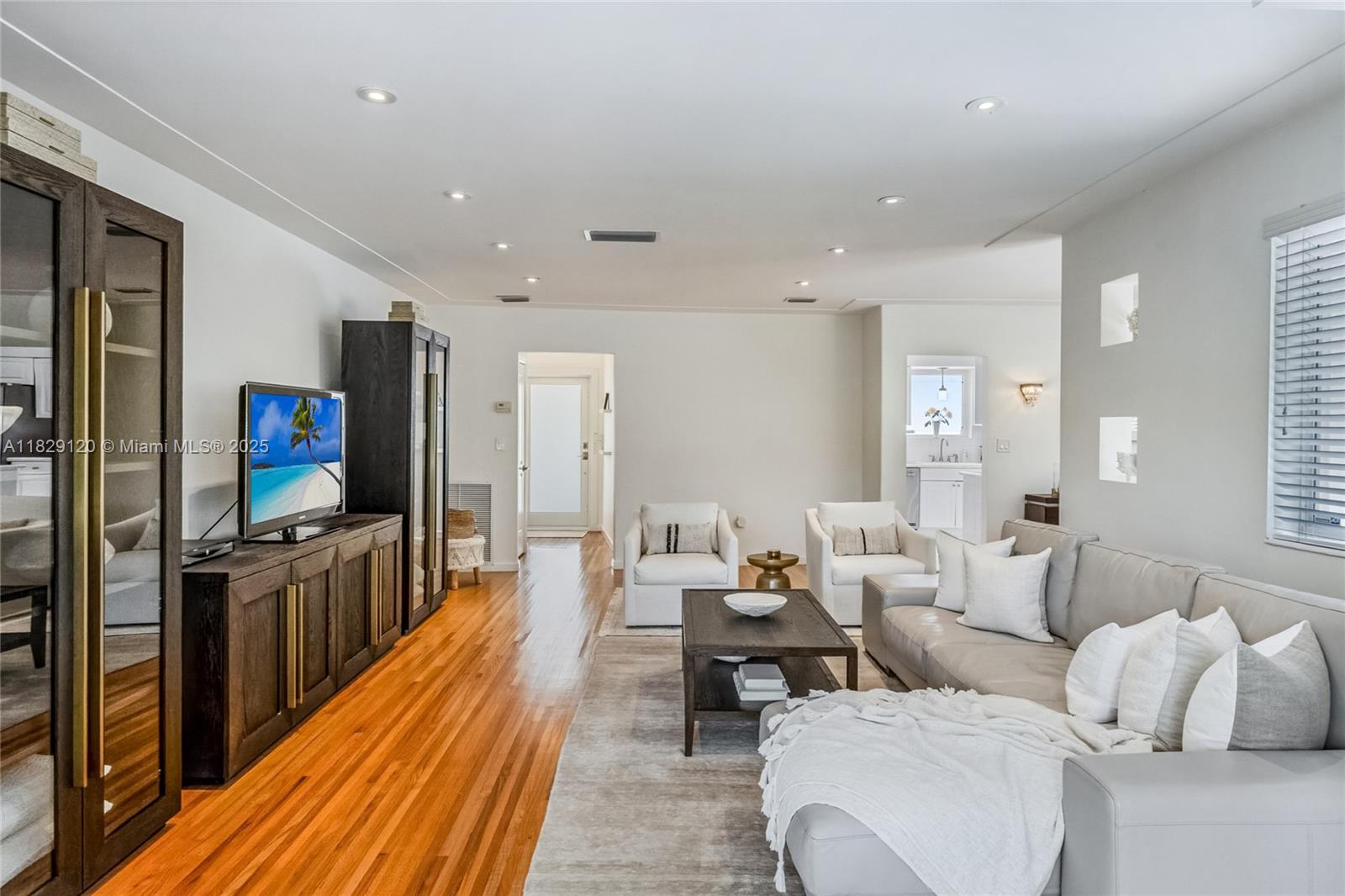 8811 Hawthorne Avenue Surfside, FL 33154 - Photo 10 of 47 a living room with furniture a large window and a flat screen tv