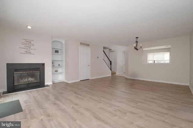 a view of empty room with wooden floor and fireplace